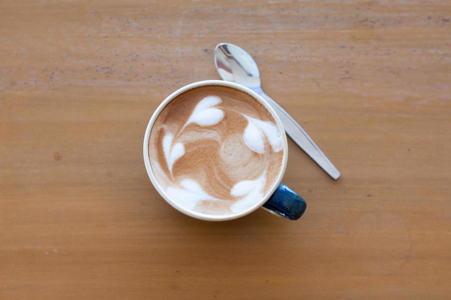 Close up a cup of hot latte art coffee on wooden table photo