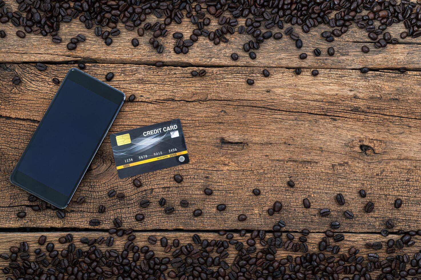 Smartphone, credit card and coffee beans on the desk photo