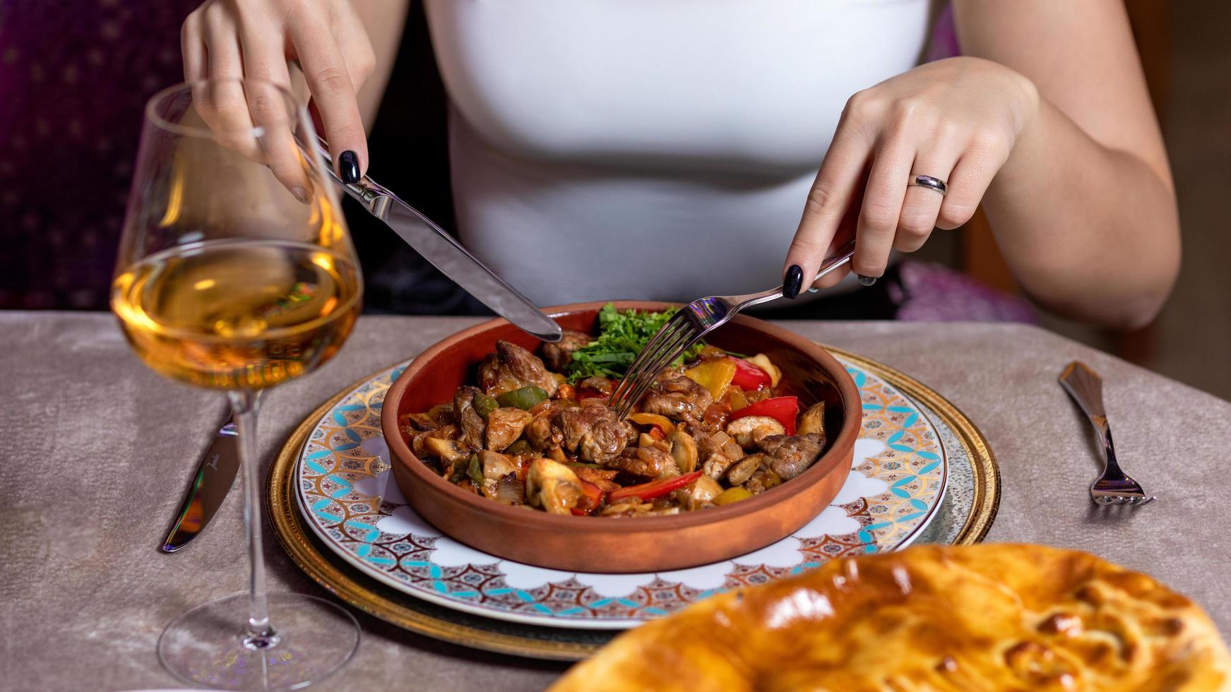 Woman eating meat with wine photo