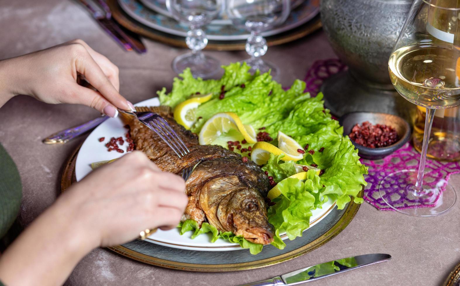 mujer comiendo un pescado entero foto