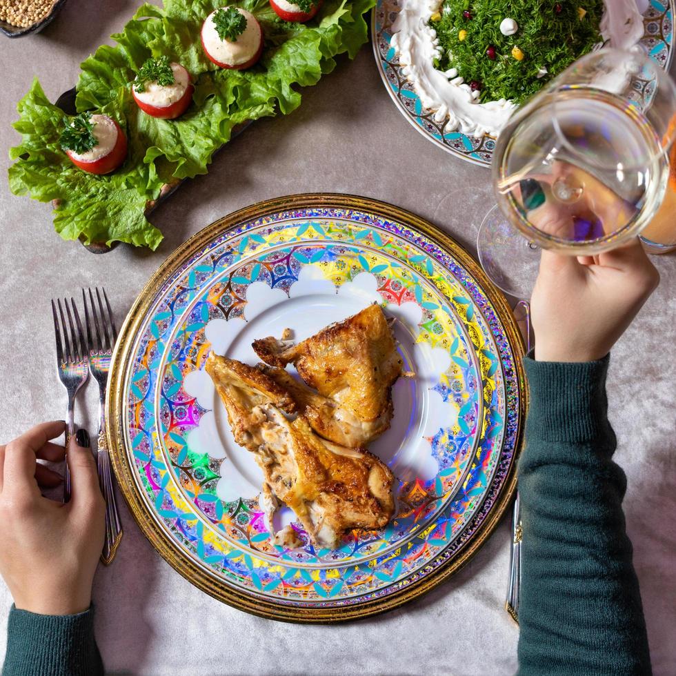 Mujer sosteniendo vino blanco mientras está sentado en una comida foto