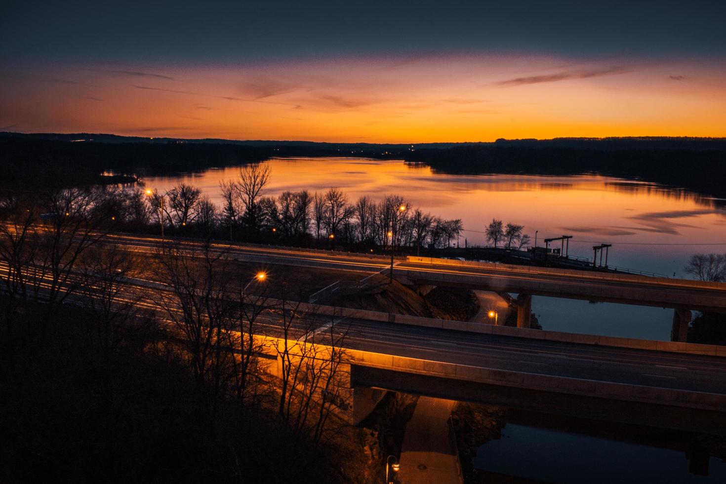 cielo anaranjado sobre el puente y el río al atardecer foto