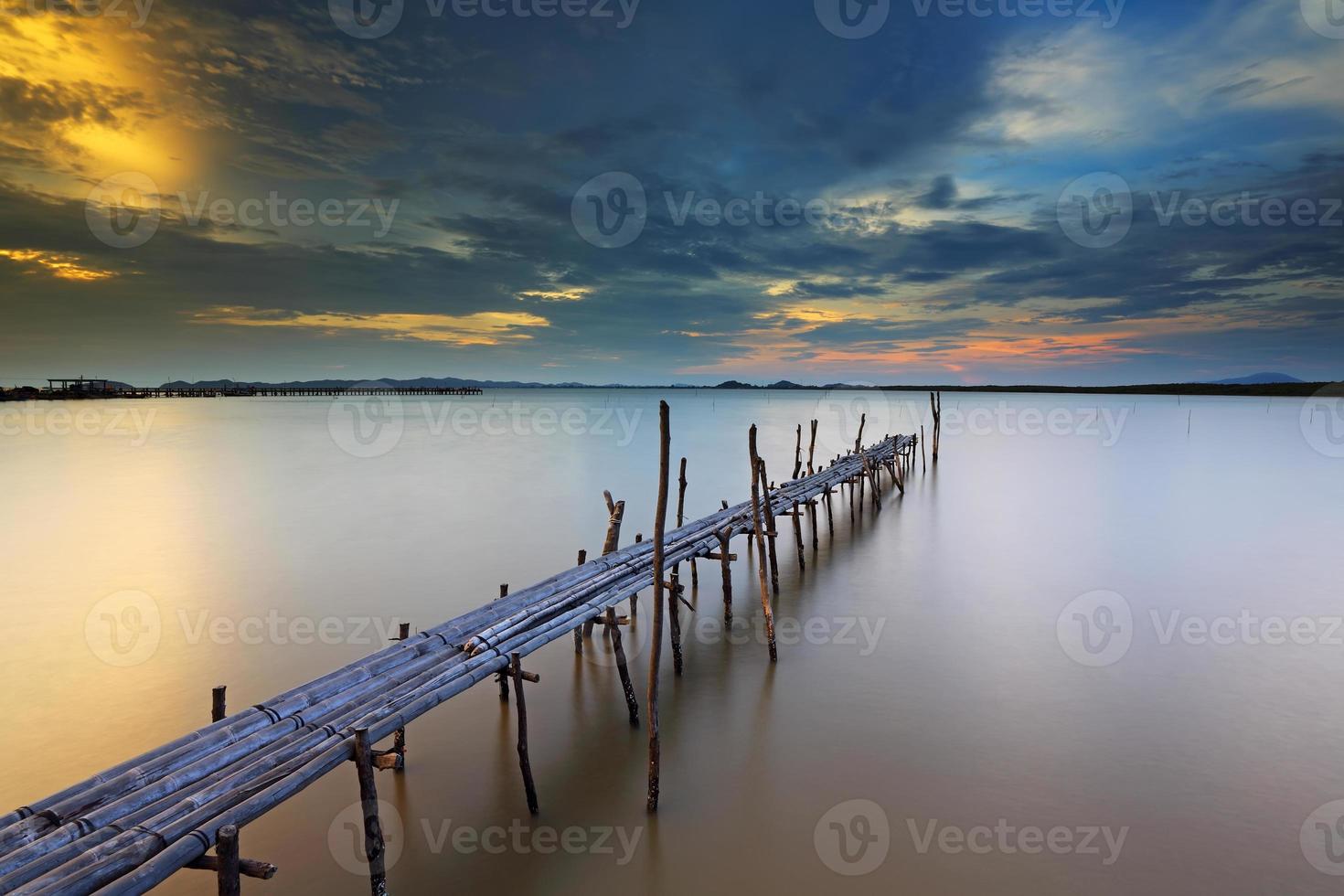 puesta de sol en el puente de bambú sobre el mar foto