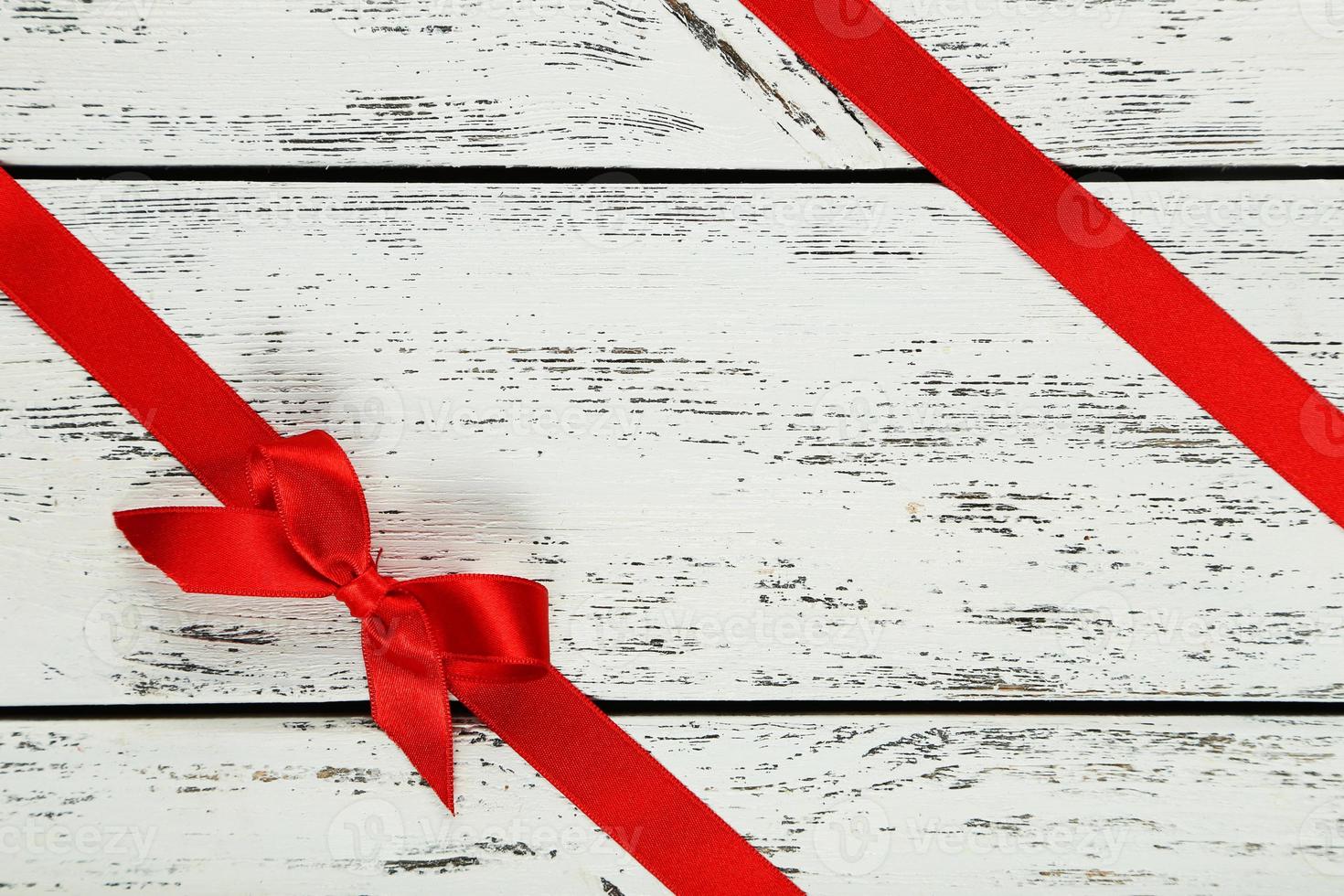 Red ribbon with bow on white wooden background 1372804 Stock Photo at