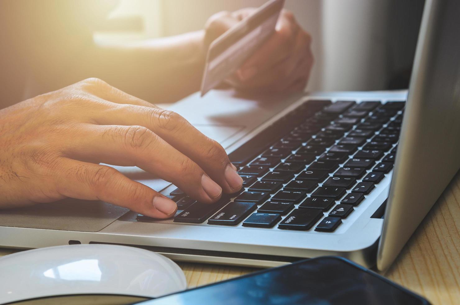 Man holding credit card at the laptop photo