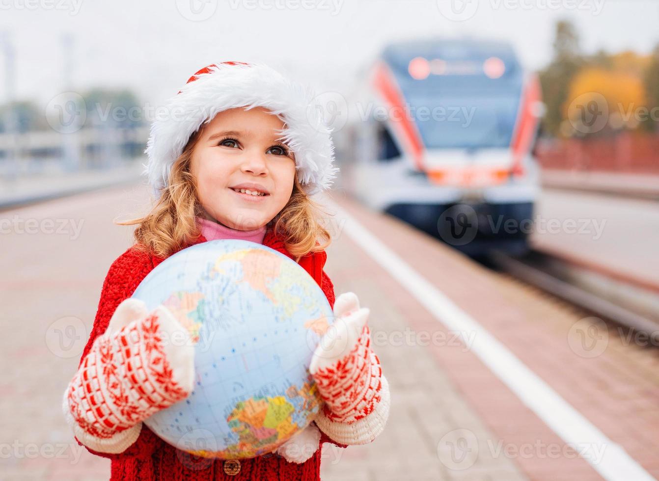 Little girl Santa travelling with a globe photo