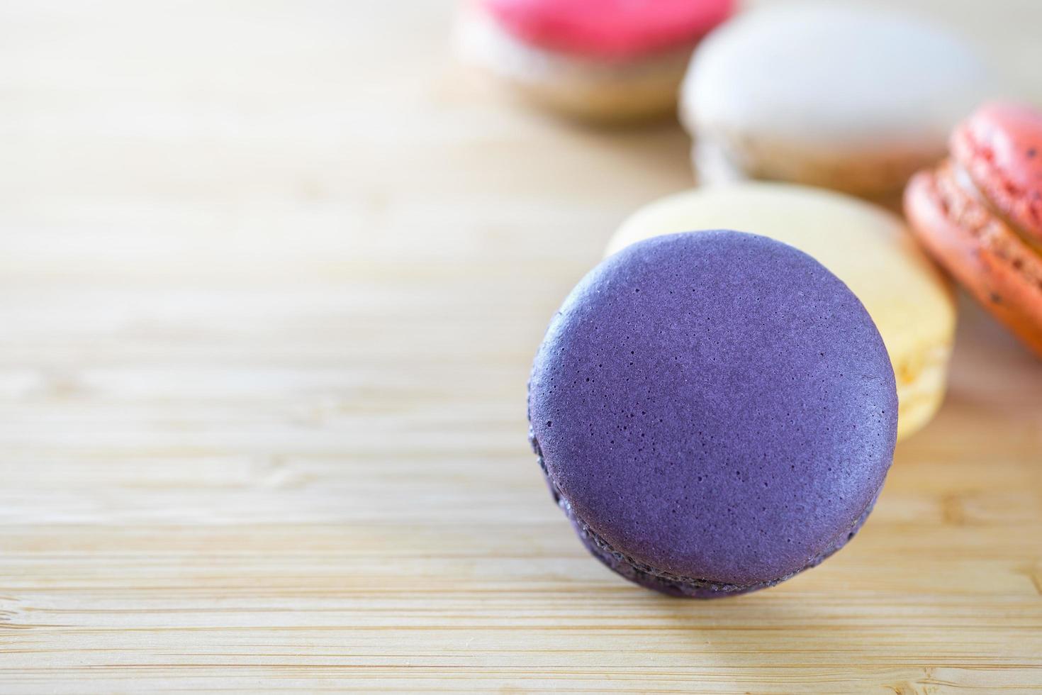 Colorful macarons on brown wooden surface photo