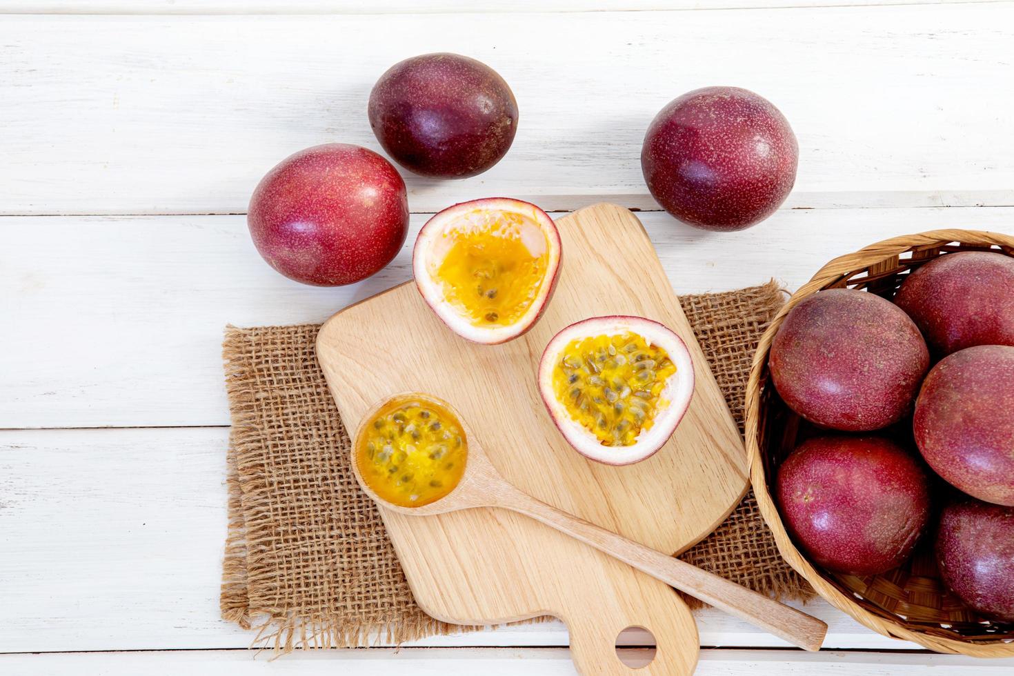 Cerrar una fruta de la pasión fresca sobre fondo de mesa de madera blanca foto