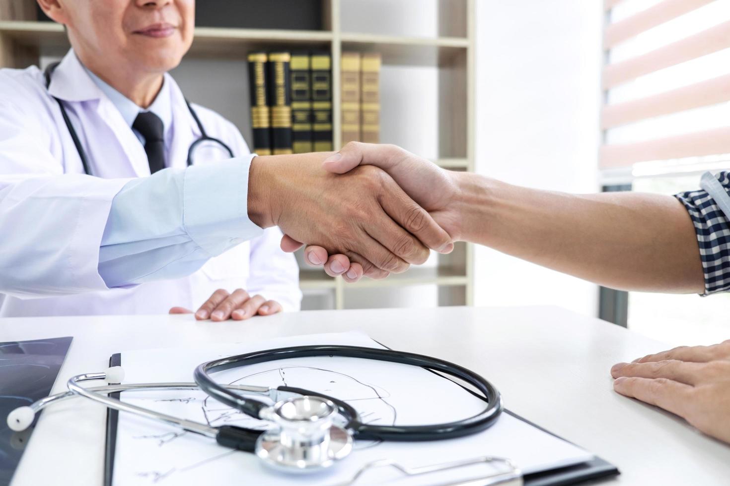 Doctor shaking hands with patient  photo