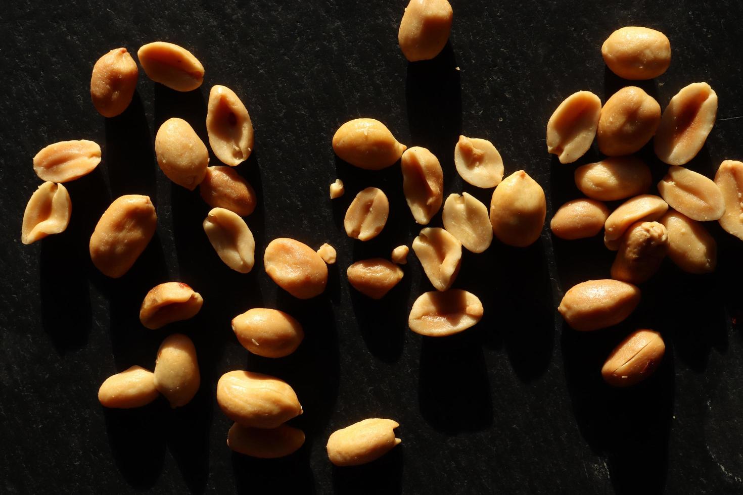 Photography of a handful of peanuts on slate for food background photo