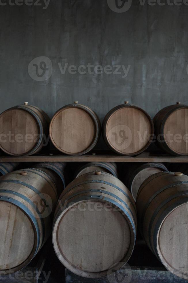 Barriles de vino apilados en la bodega de la bodega. foto