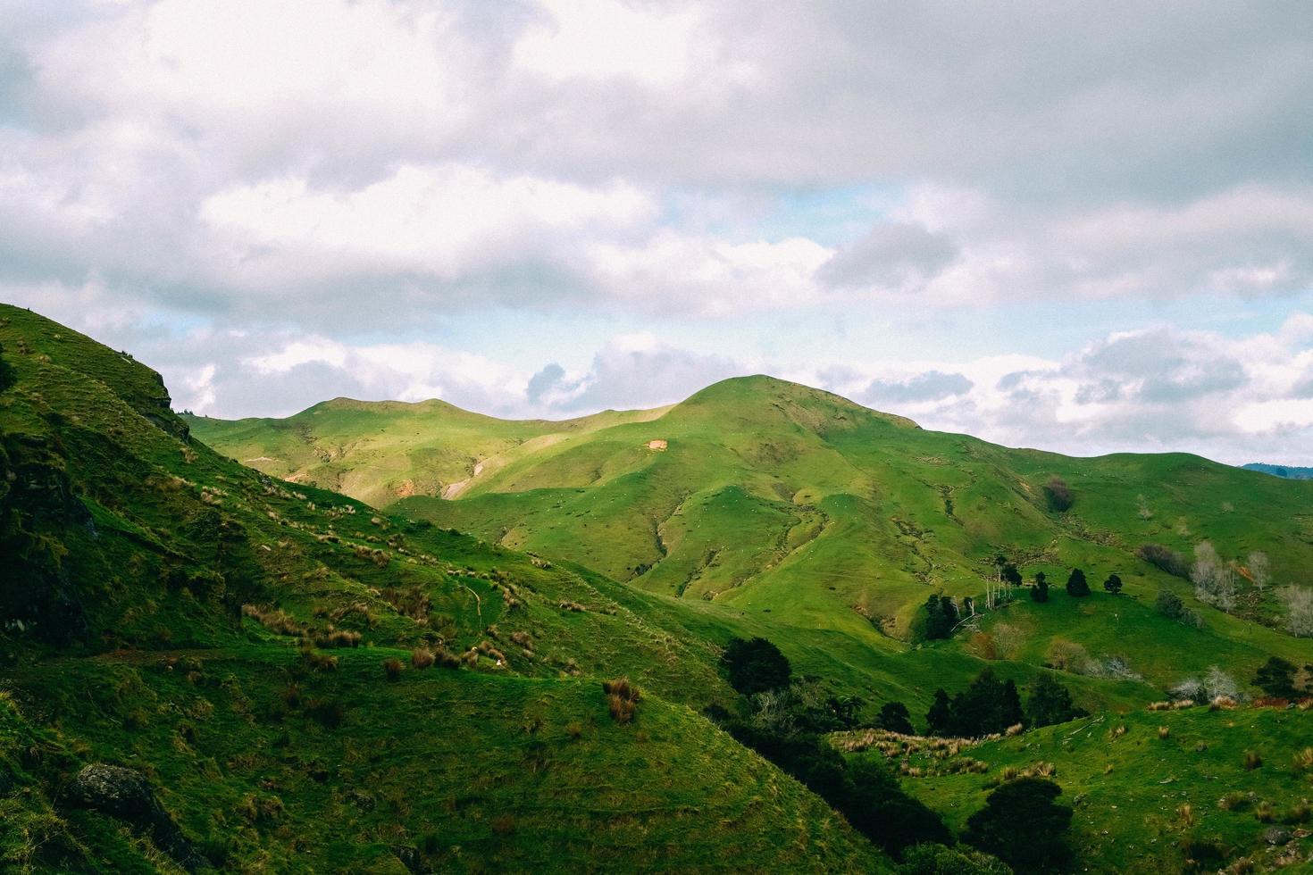 Green mountains under white clouds photo