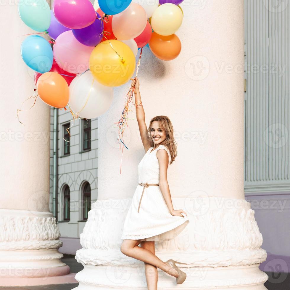 beautiful lady holding a bunch of balloons photo