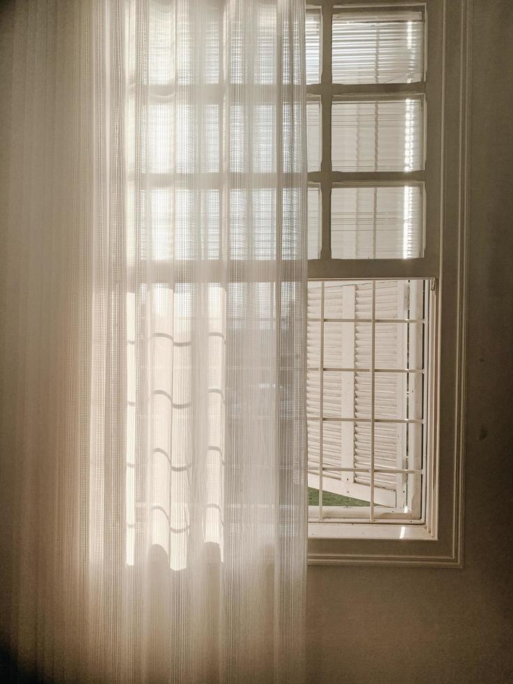 Opened white window with sheer curtain photo