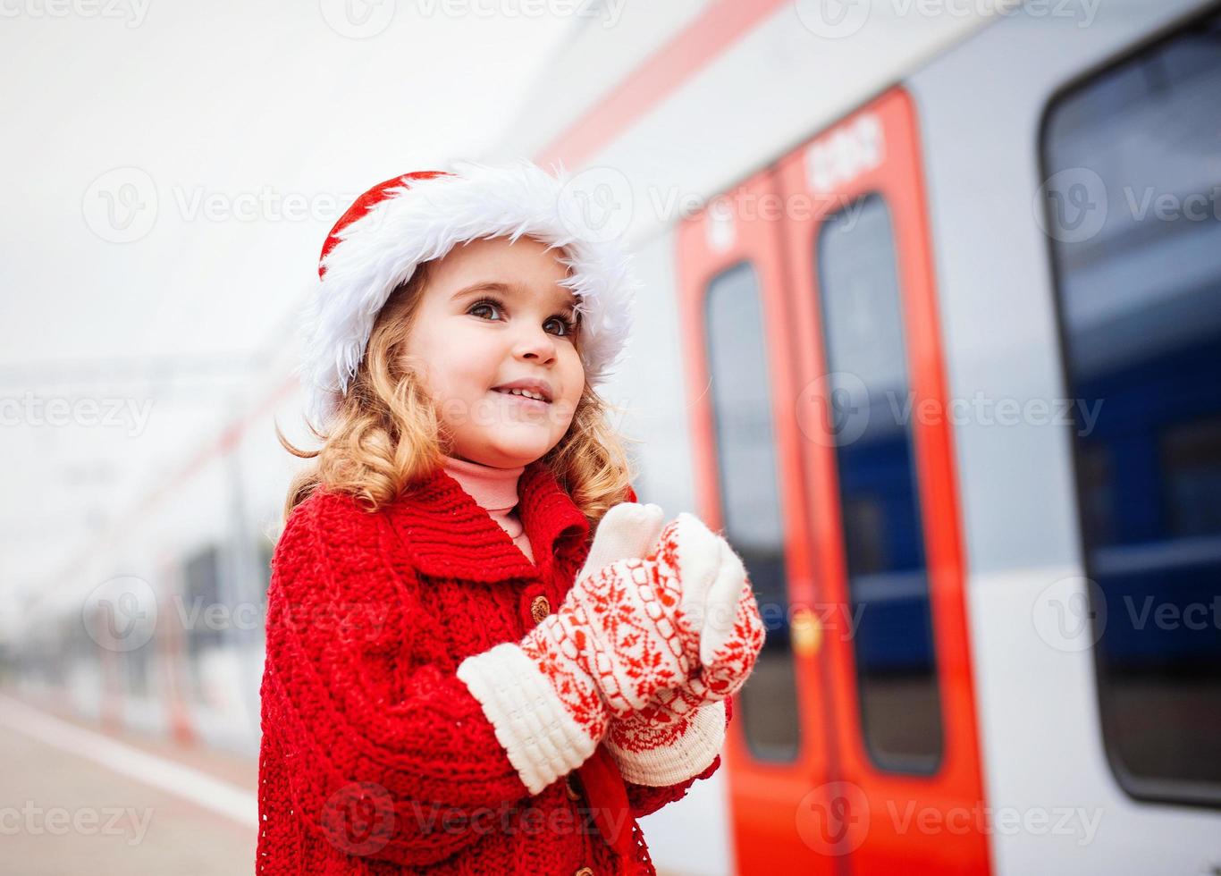 Little girl Santa waiting for a train photo