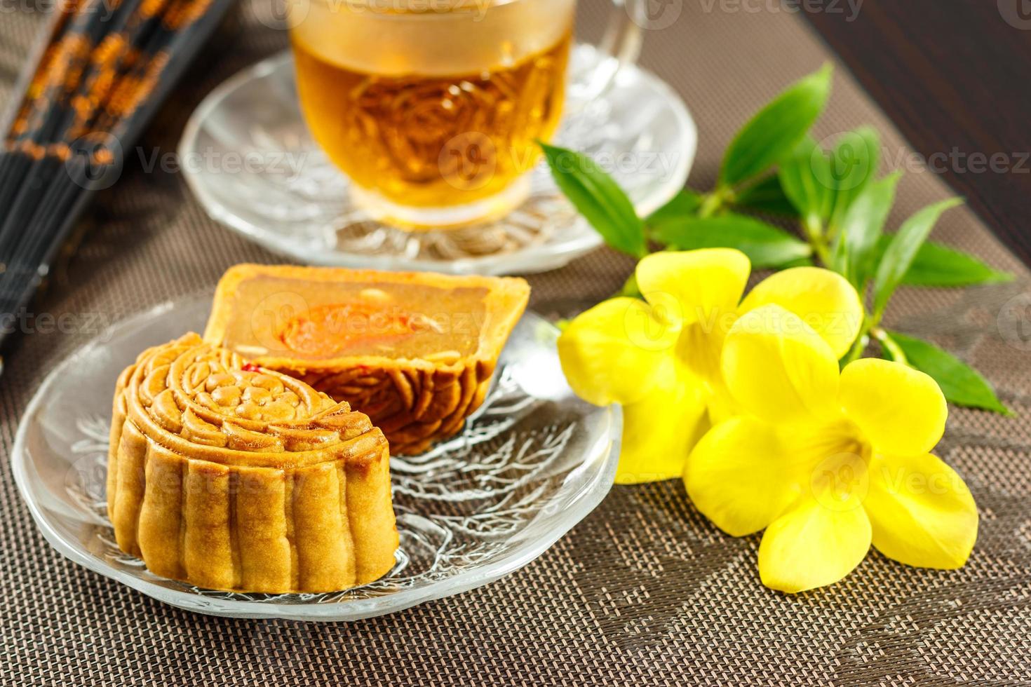 delicioso pastel de luna y té caliente con elementos de una flor amarilla. foto
