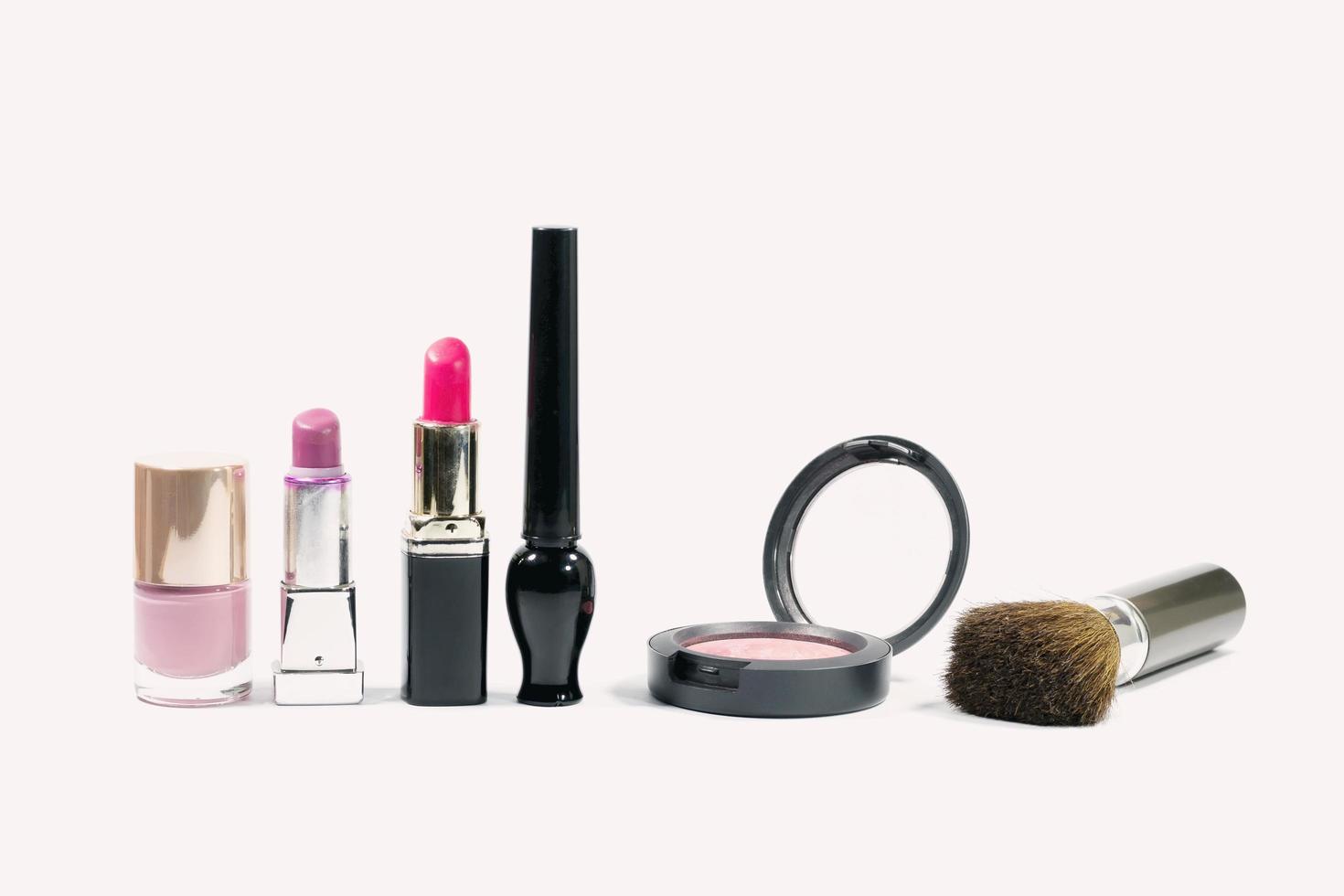 cosméticos de maquillaje sobre un fondo rosa claro. foto