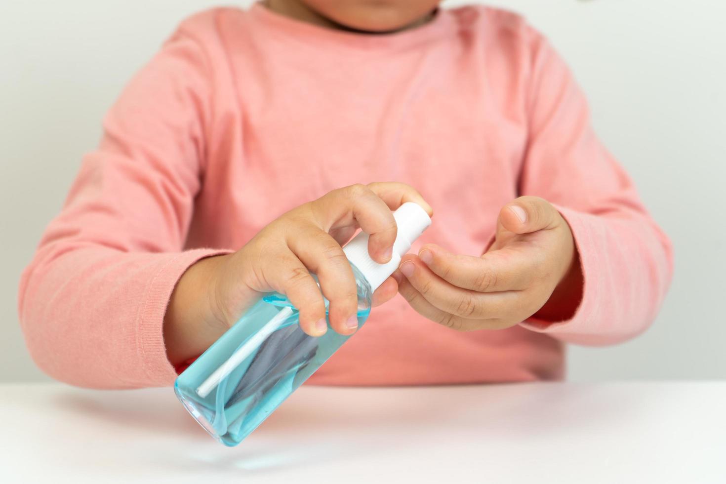 niña pequeña usando desinfectante foto