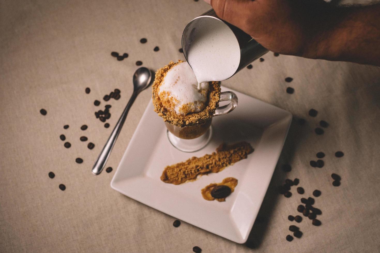 Person reaching into frame preparing coffee dessert photo