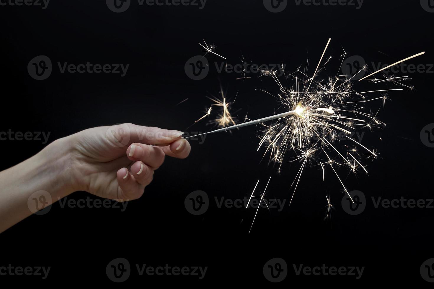 woman's hand holding a sparkler photo