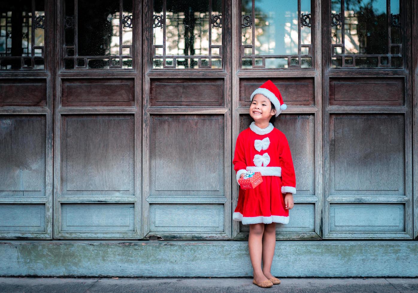 chica asiática en traje rojo de santa claus foto