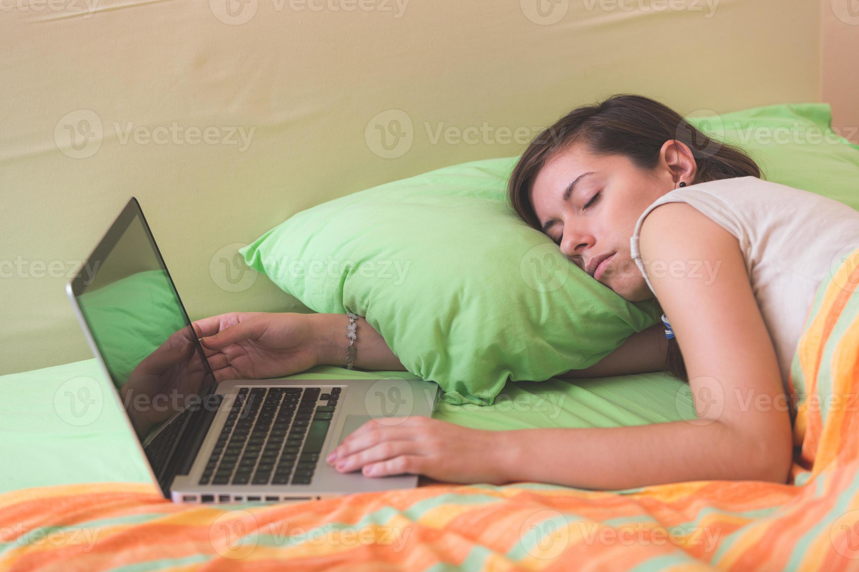 Young Woman Falling Asleep while Using Notebook on Bed 1408887 Stock