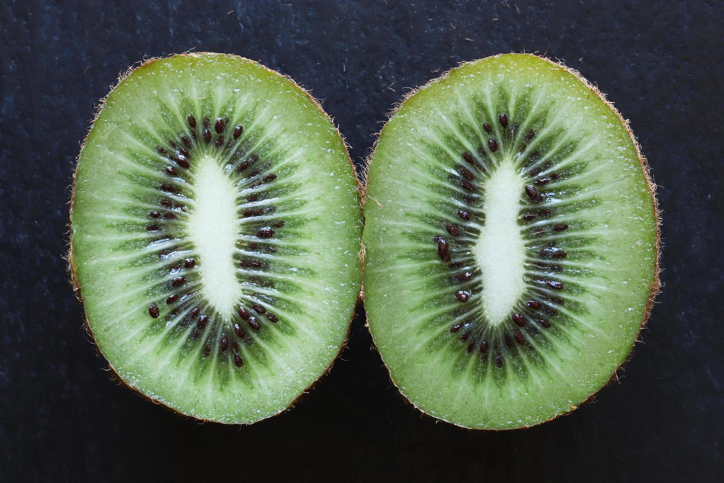 Cut kiwi on slate background photo