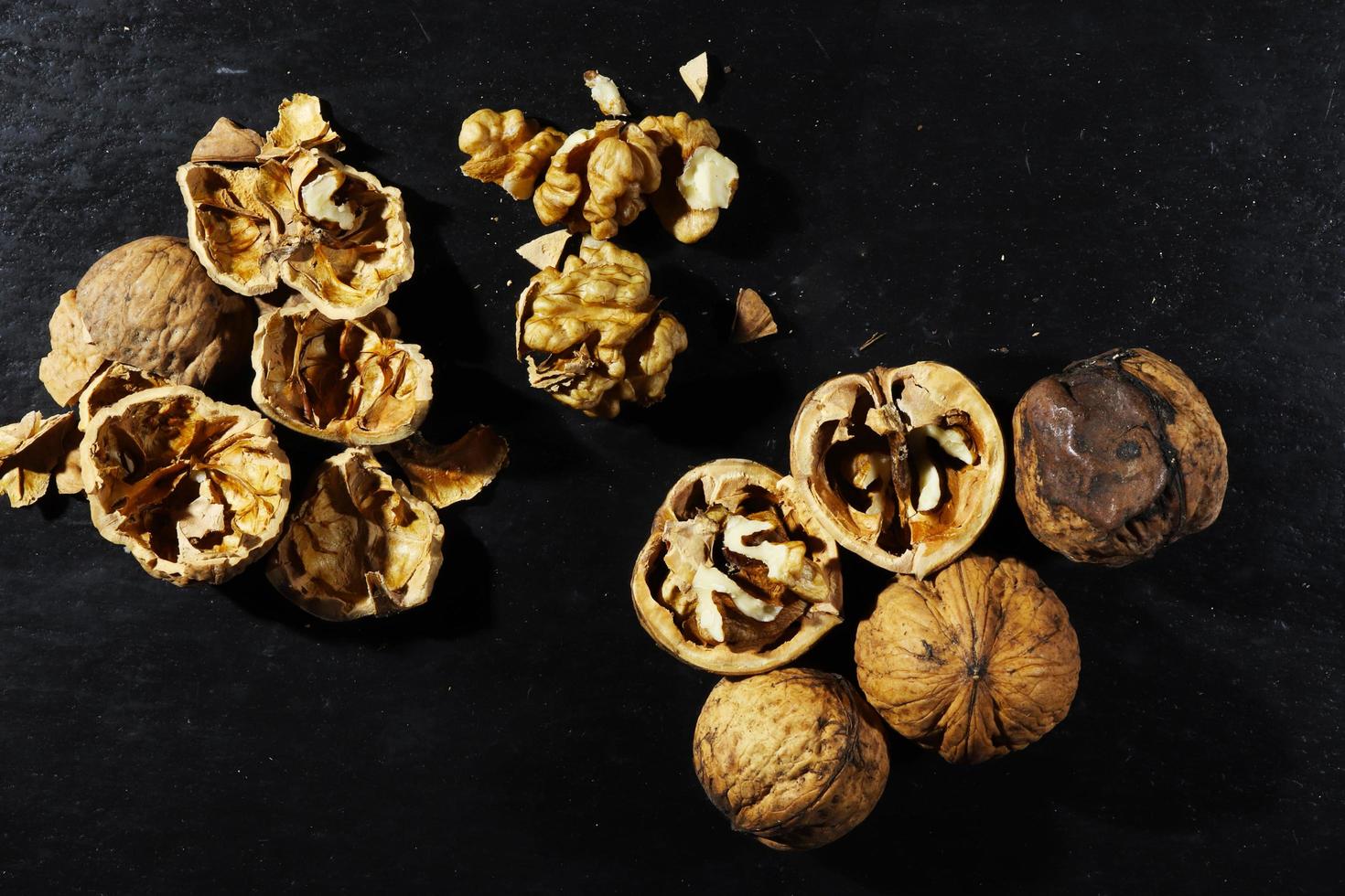 Whole and broken walnuts on slate background photo