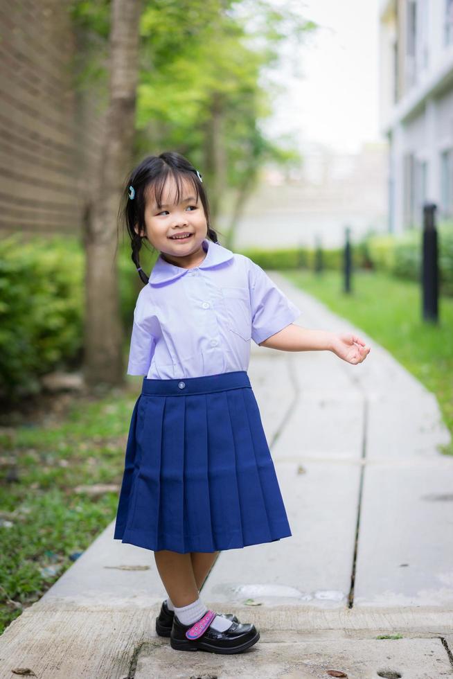 Portrait of happy little girl in Thai school uniform photo