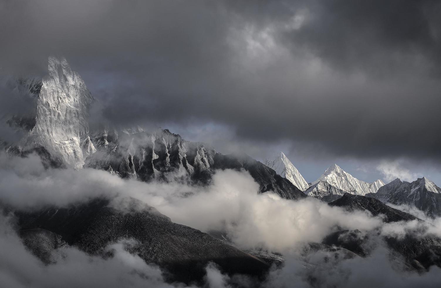 Snowy mountain peaks under dark clouds in Nepal photo