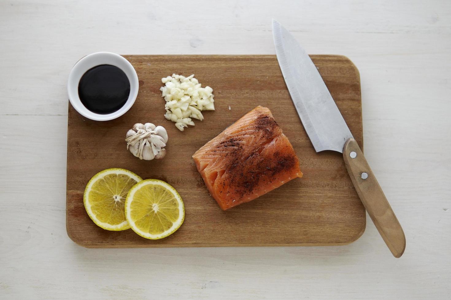 Salmon and lemon on cutting board photo