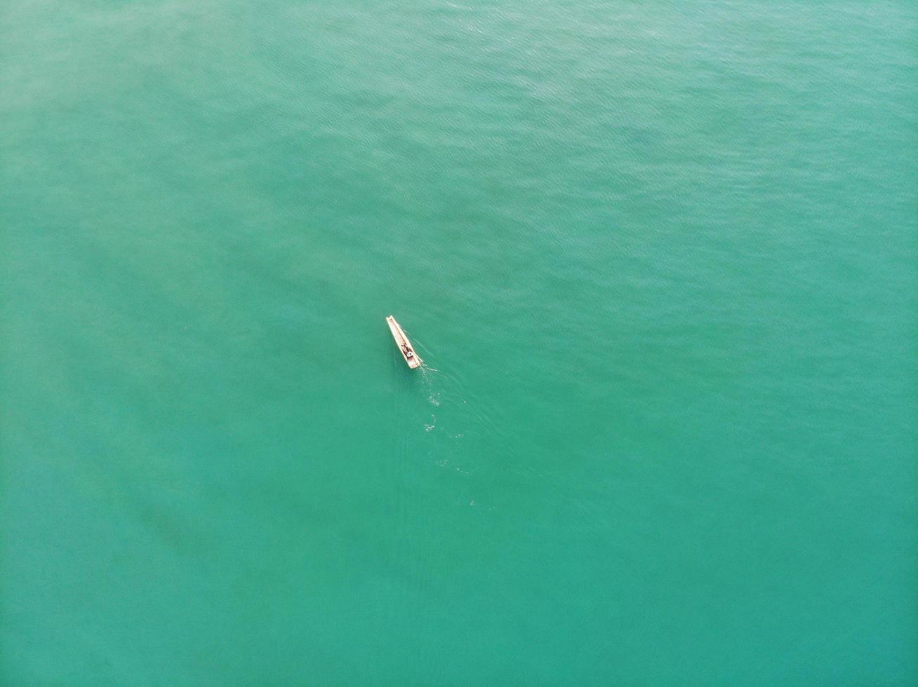 Aerial view of a boat on a green sea photo