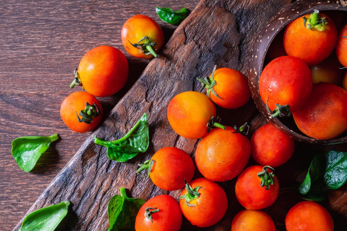 Tomates frescos sobre fondo de madera foto