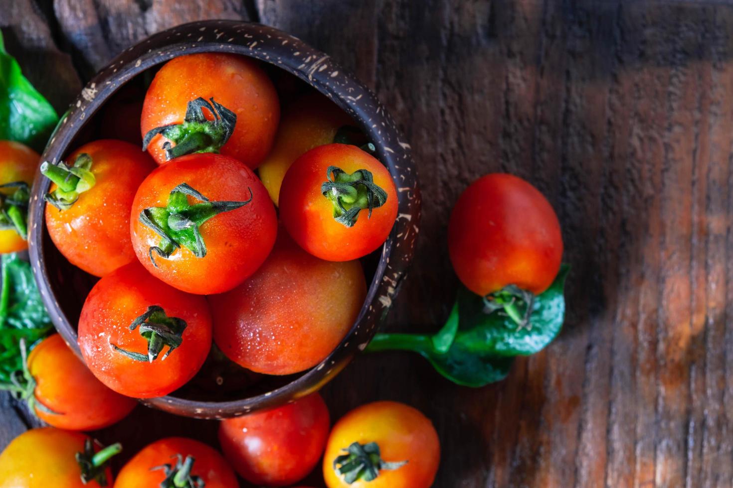 Tomates frescos sobre fondo de madera foto