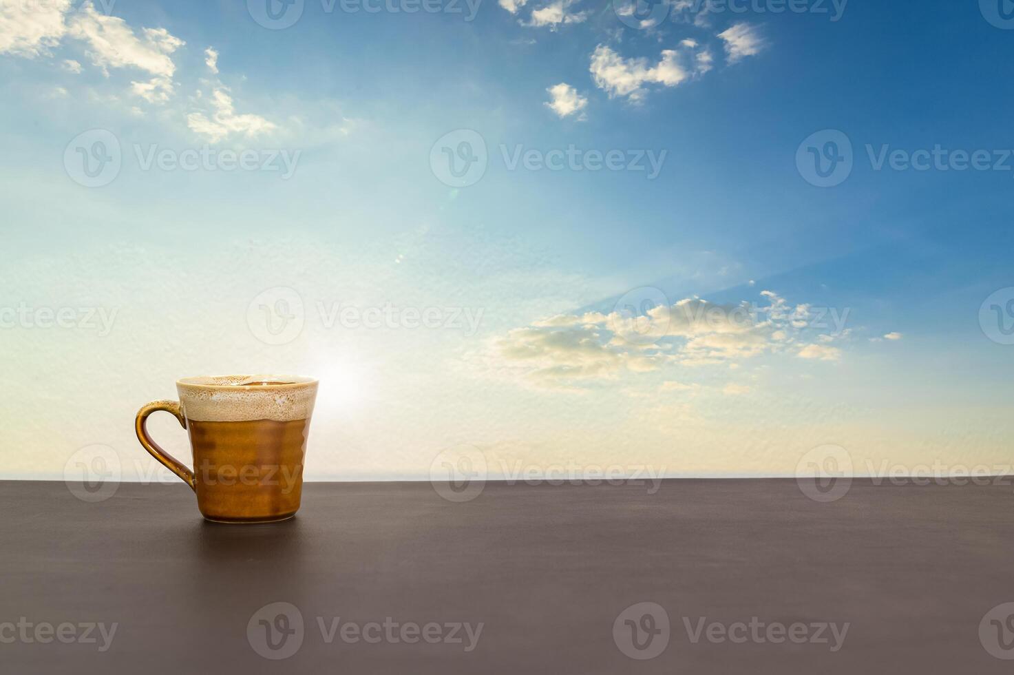 Coffee mug on the table with a view of the sky and clouds photo
