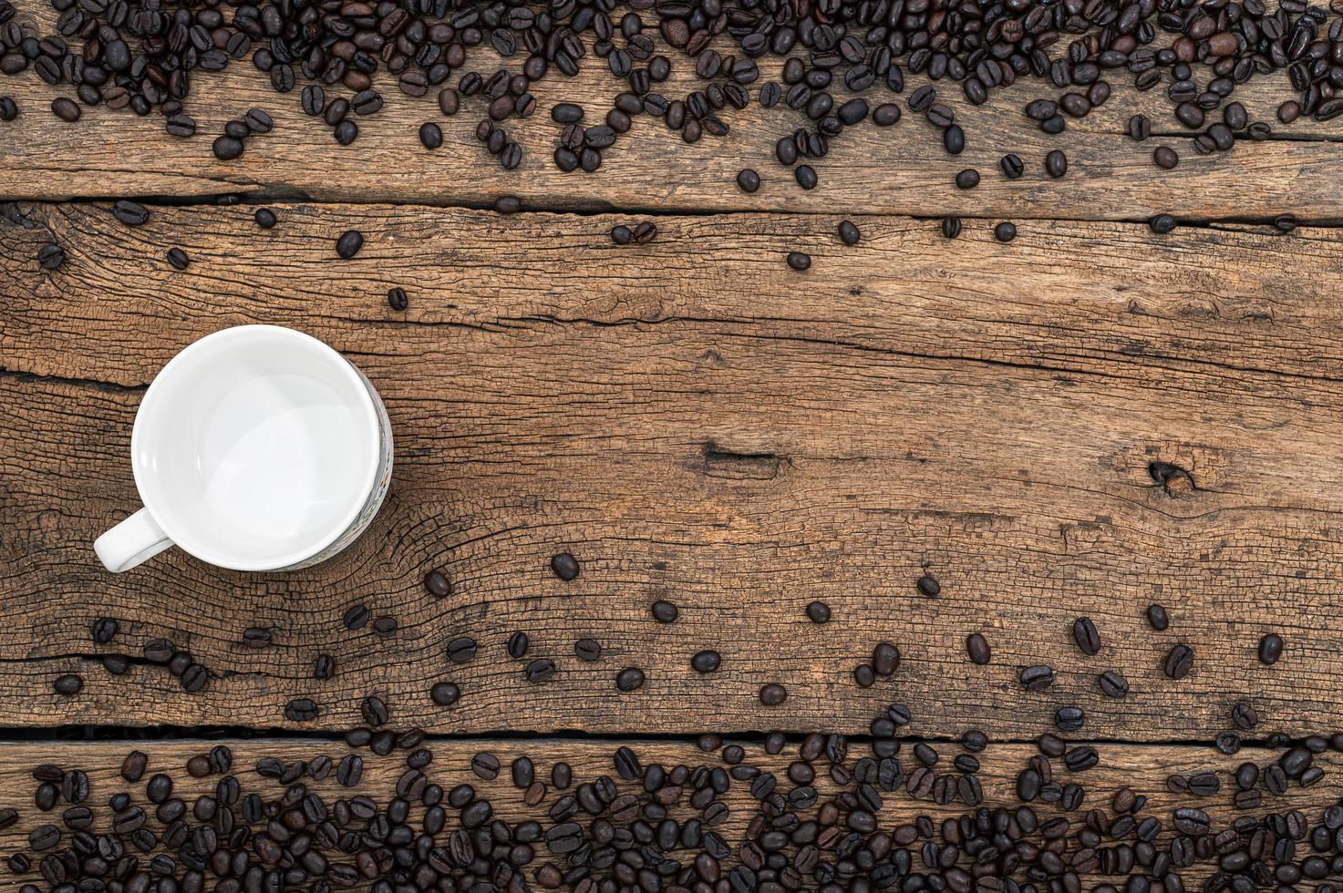 Empty mug and coffee beans on the desk photo