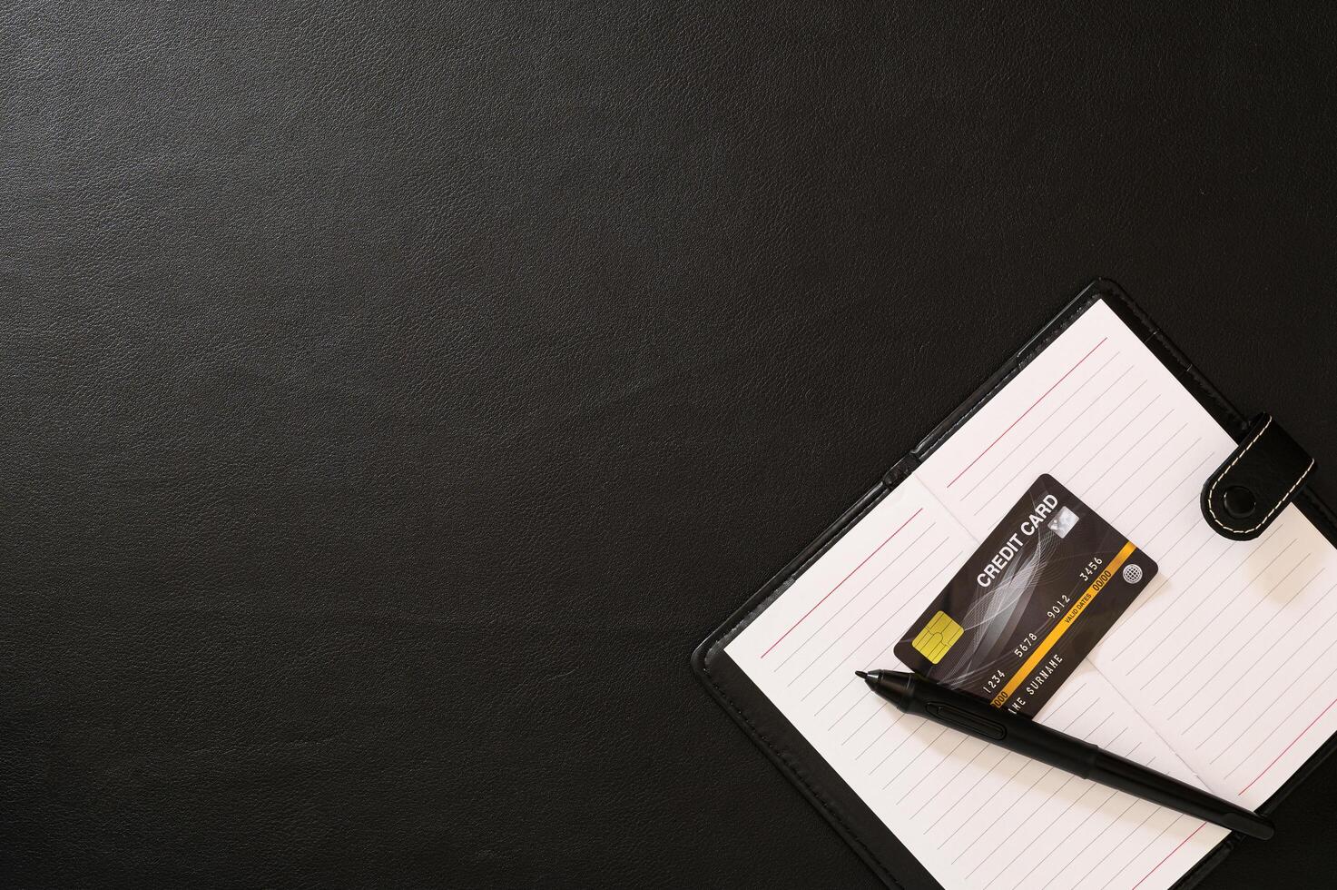 Notebook, pen and credit card on the desk photo