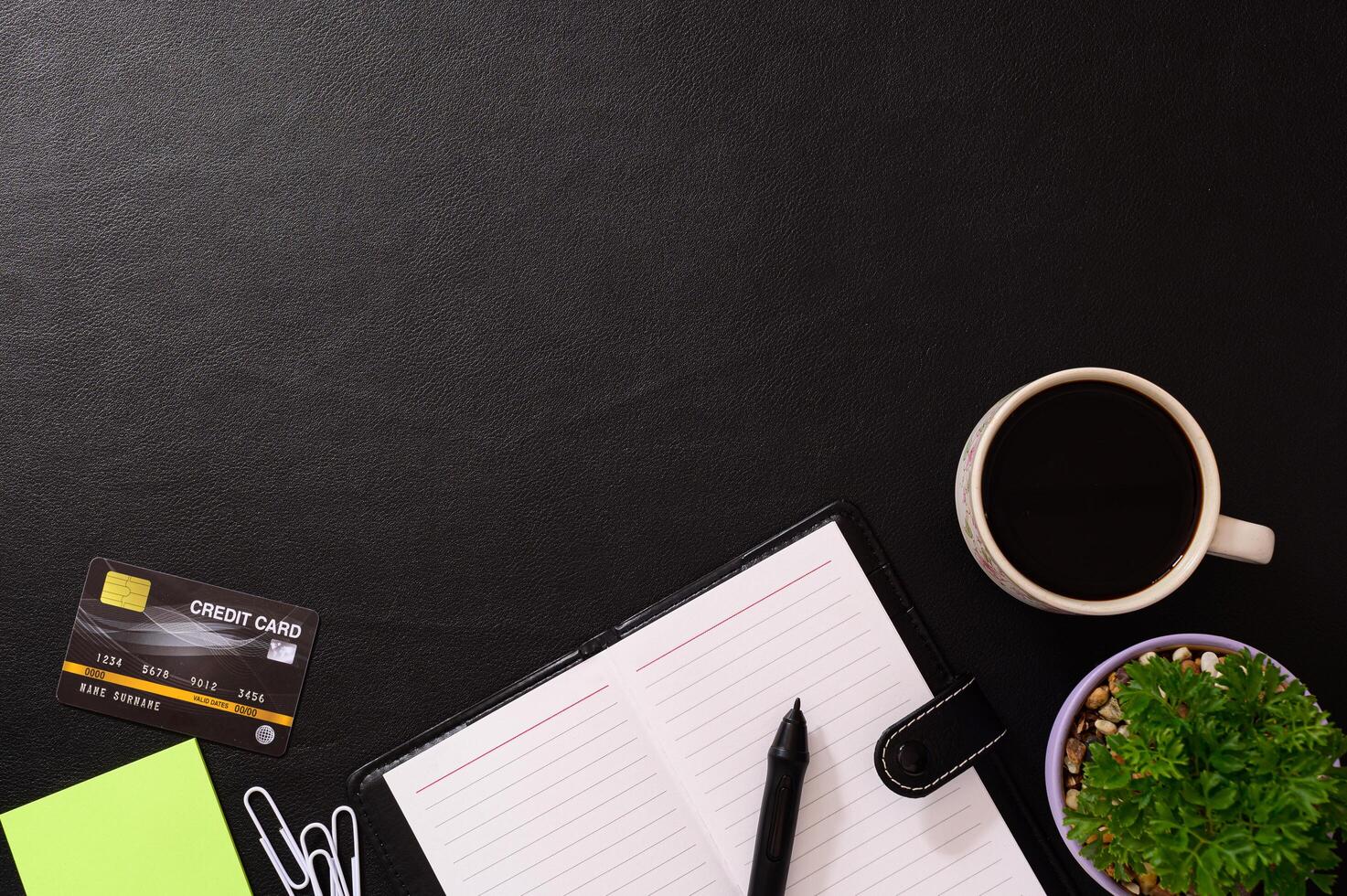 Notebook, credit card and a coffee mug on the desk photo