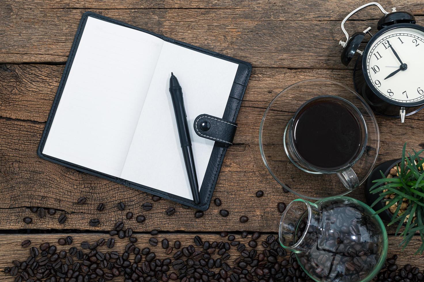 cuaderno y granos de café en el escritorio foto