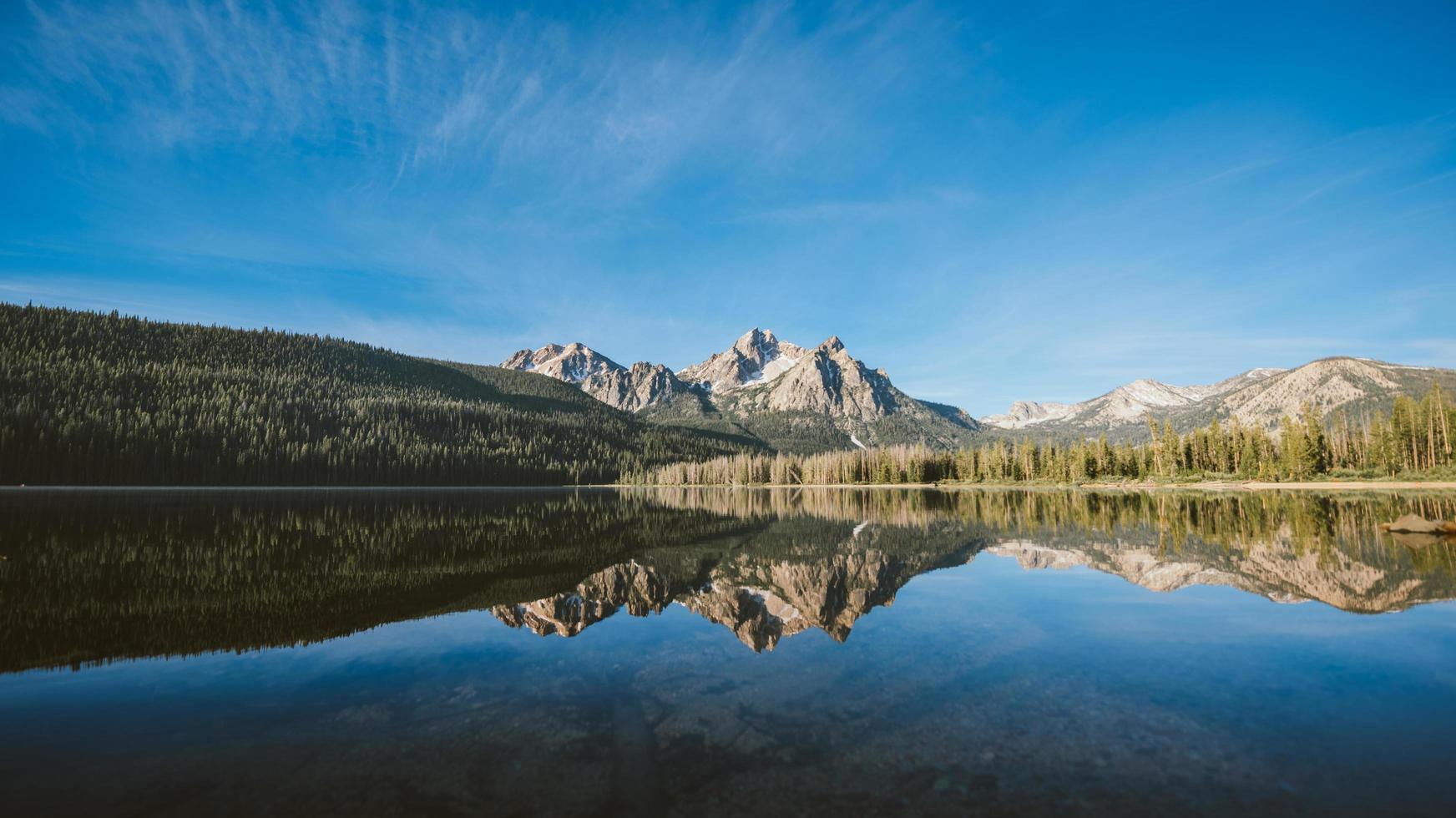 montañas y bosque reflejo en un lago foto