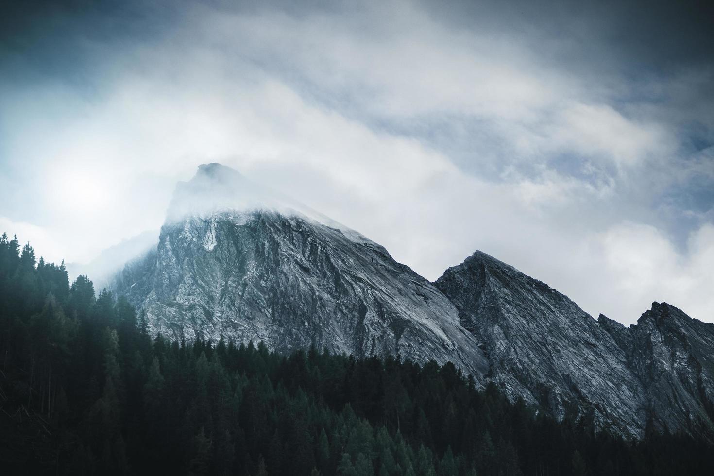 pico de la montaña alcanzando las nubes foto