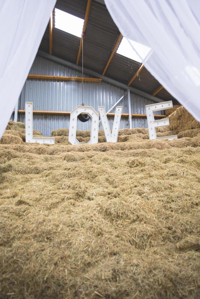 LOVE letters set up on a haystack at wedding location photo