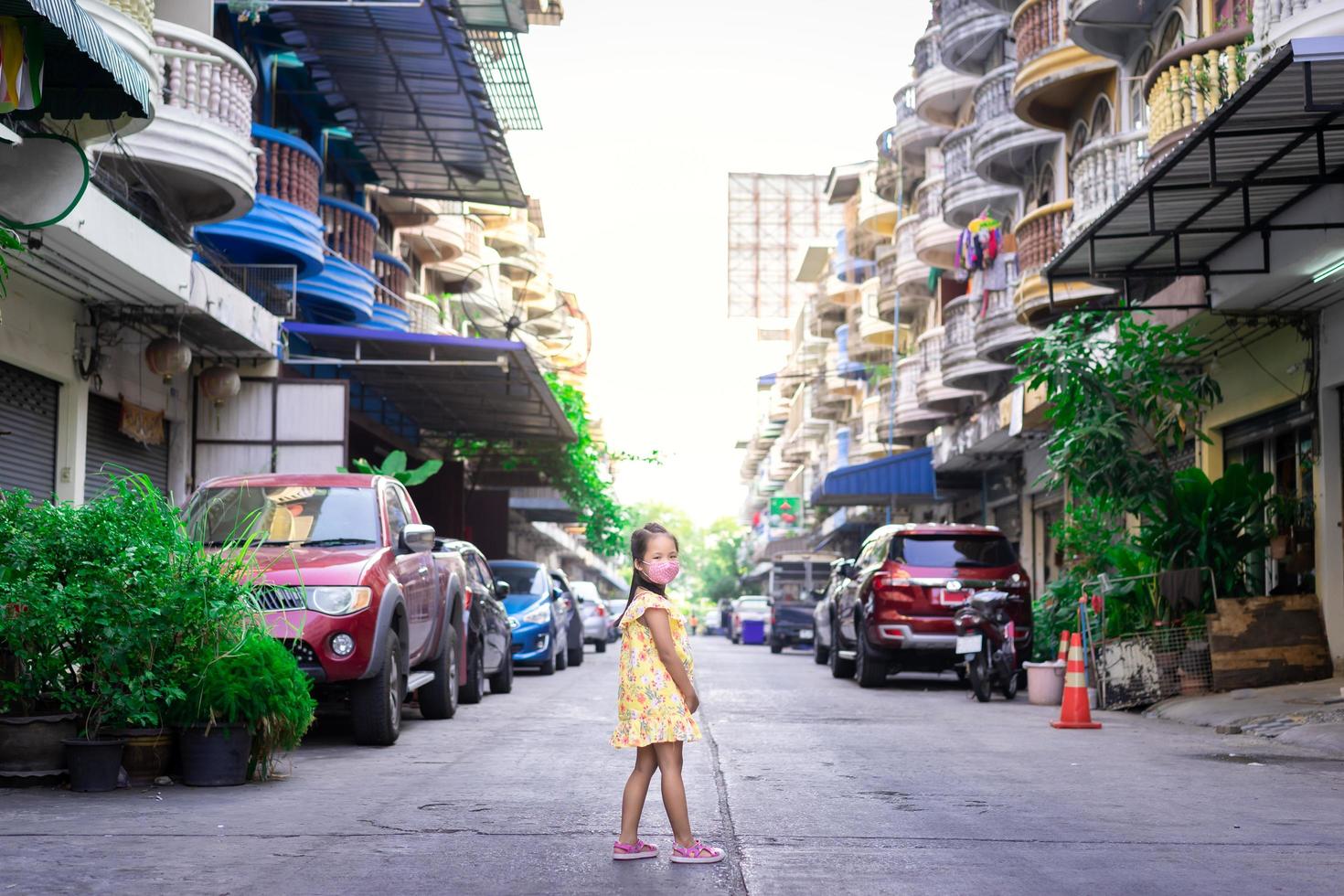 Little Asian girl wearing a mask against dusk and covid-19 photo