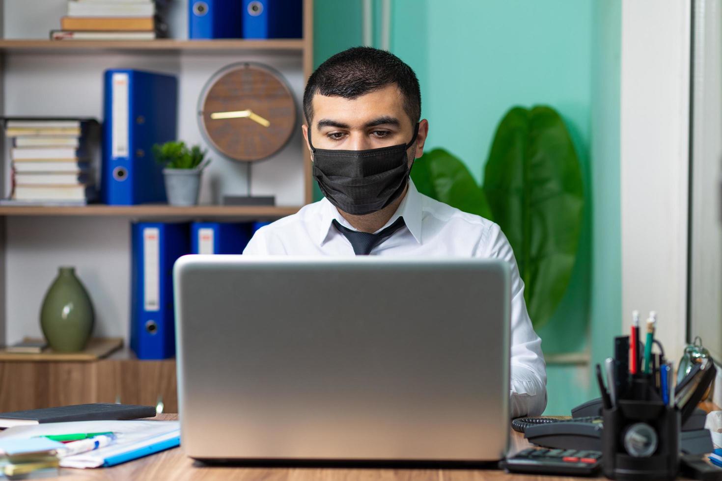 Hombre de negocios joven con máscara protectora médica negra foto