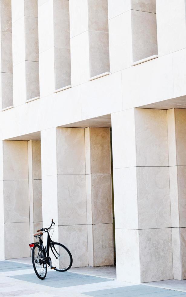 Bicicleta negra bajo el cielo soleado junto al edificio foto