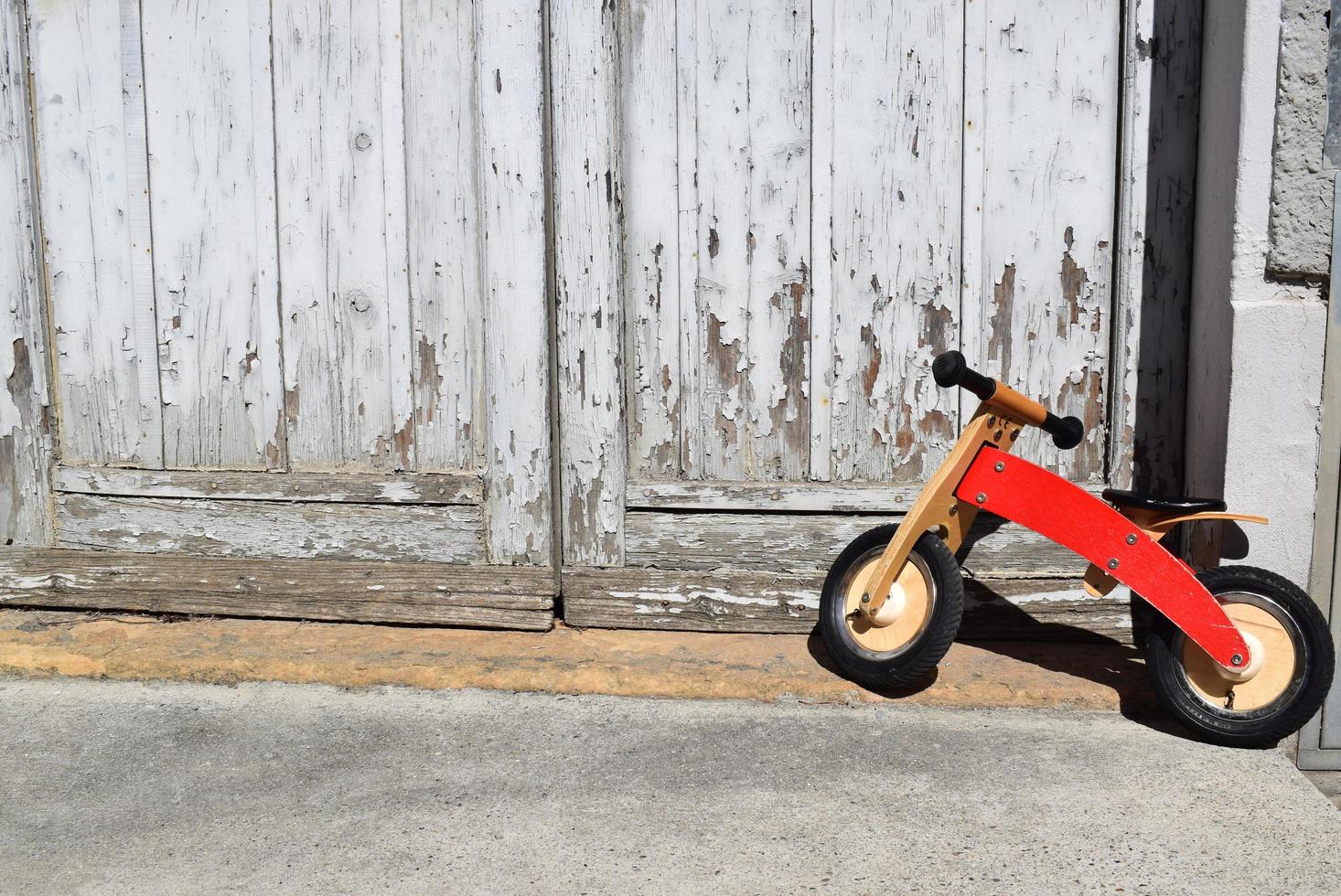 Parque de bicicletas naranja para niños pequeños junto a la puerta foto