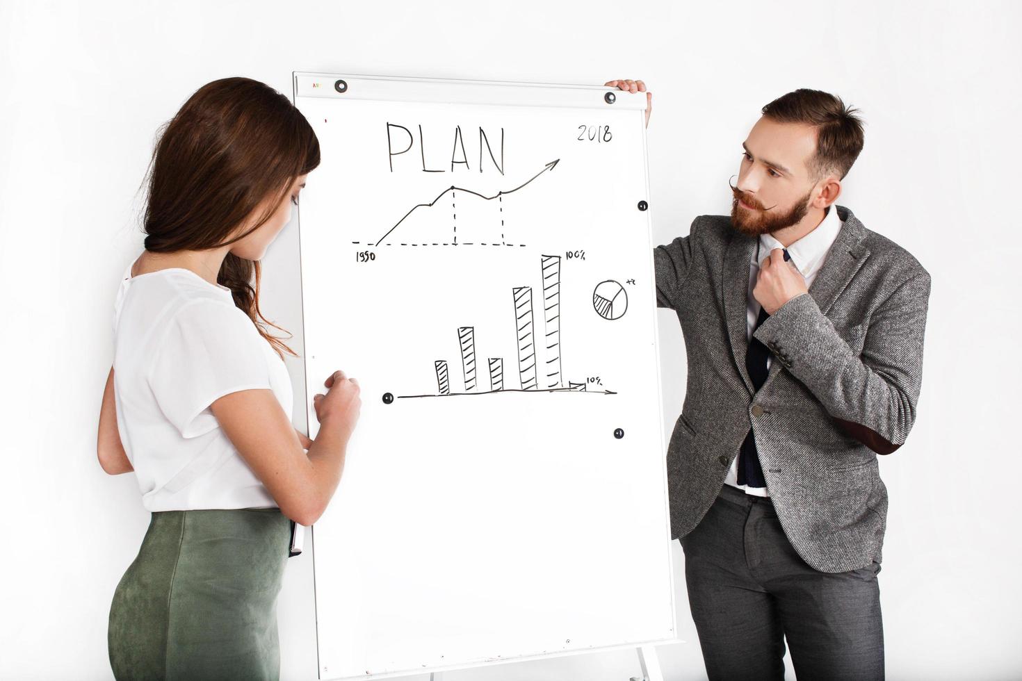 Businessman and woman discuss graph written on white board photo