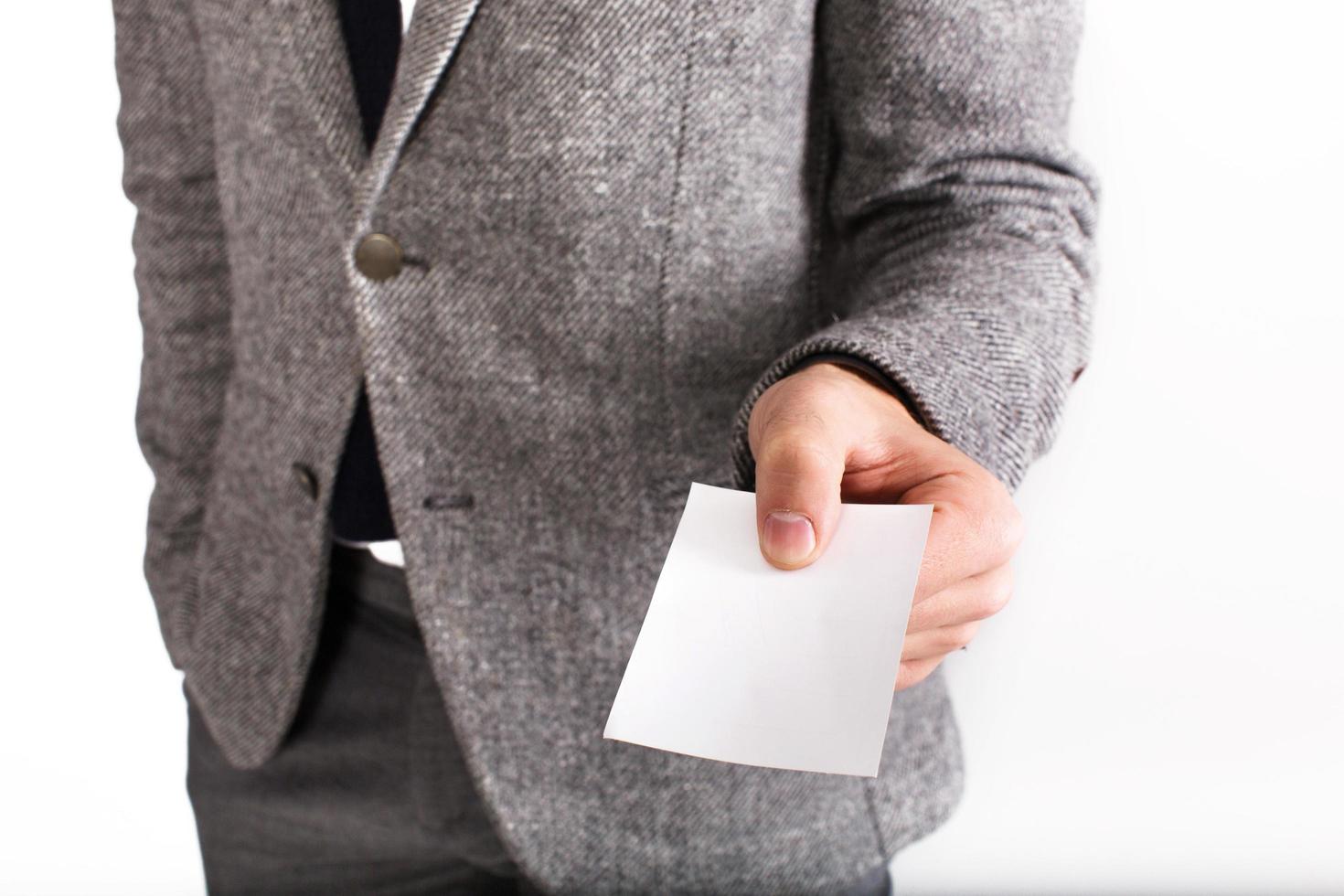 Man in gray business suit holds blank white card photo