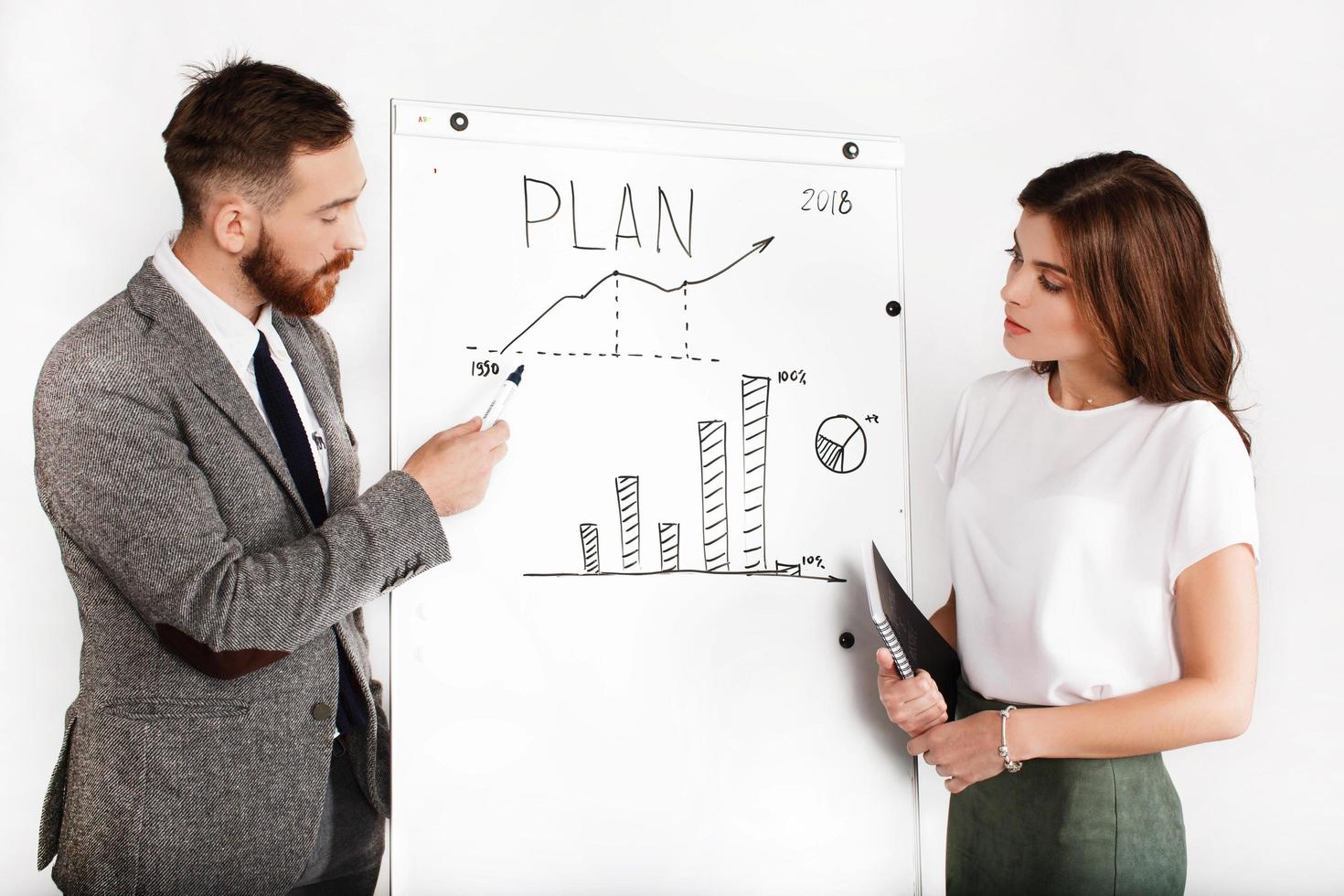 Businessman and woman debate about graph on white board photo