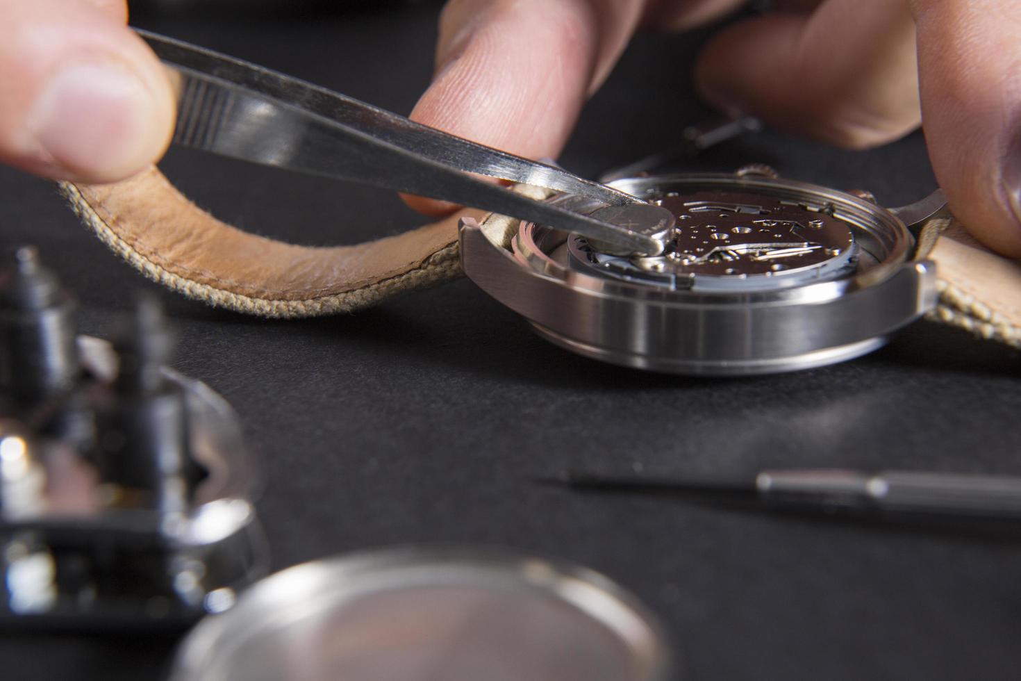 Close-up of watchmaker replacing a battery photo
